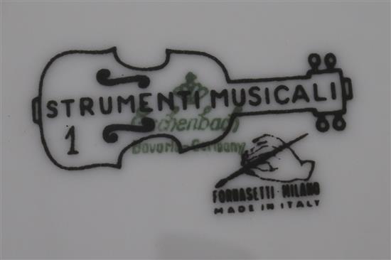 A large Fornasetti Strumenti Musicali pattern dish and four similar plates, 20.5.cm - 32cm